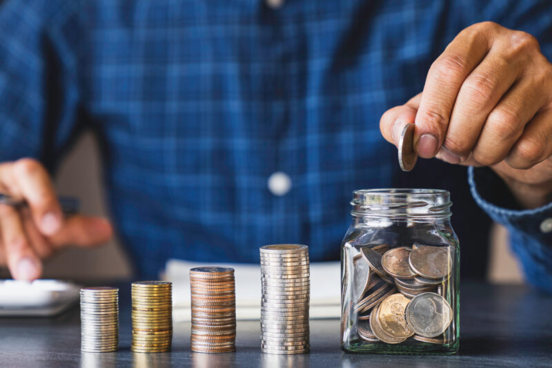 Businessman holding coins putting in glass. concept of saving money for finance accounting, for saving money wealth, Savings for Retirement Planning