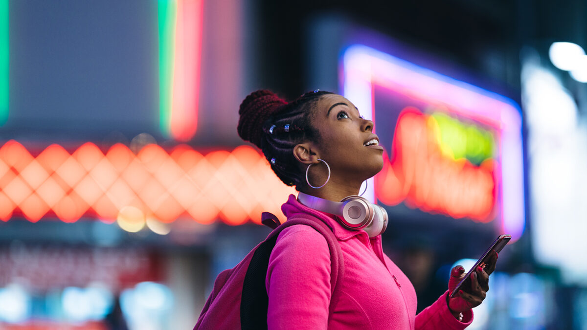 A woman is using a smart phone at night.