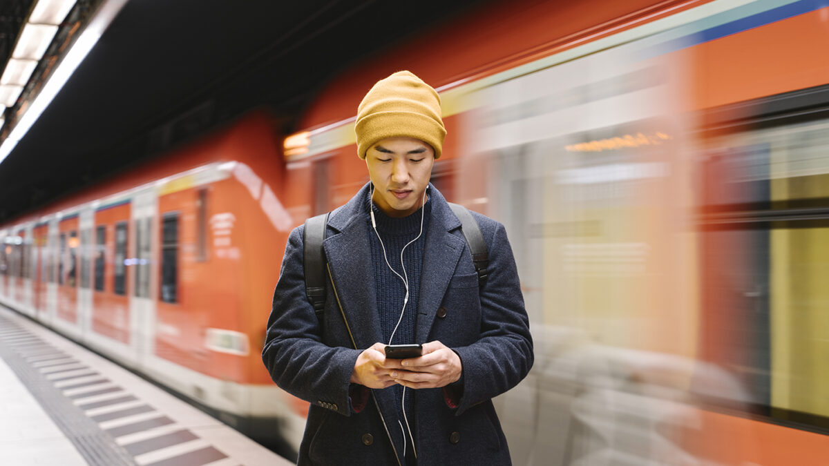 Germany, Frankfurt, Stylish man with yellow hat and earphones in metro station